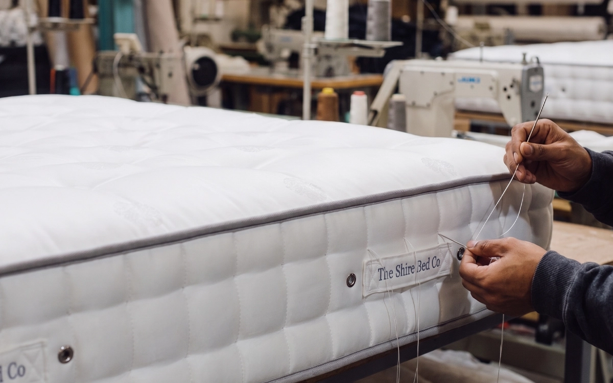 "Shire Beds craftsperson hand stitching a pocket sprung mattress in Dewsbury, Yorkshire